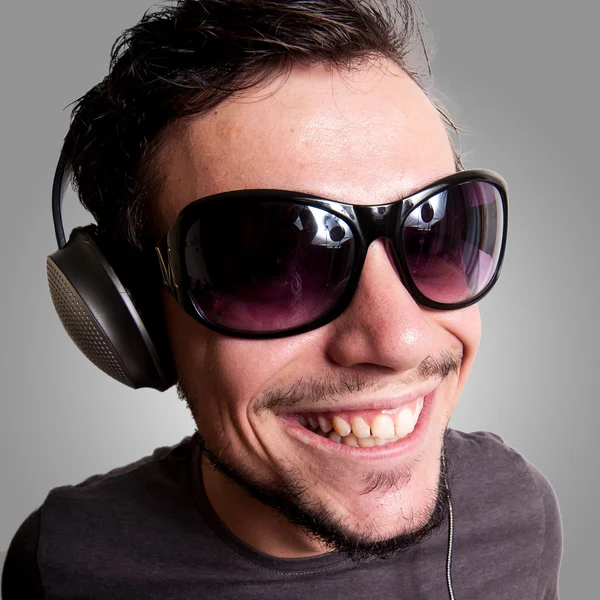Chico sonriente con auriculares y gafas de sol — Foto de Stock