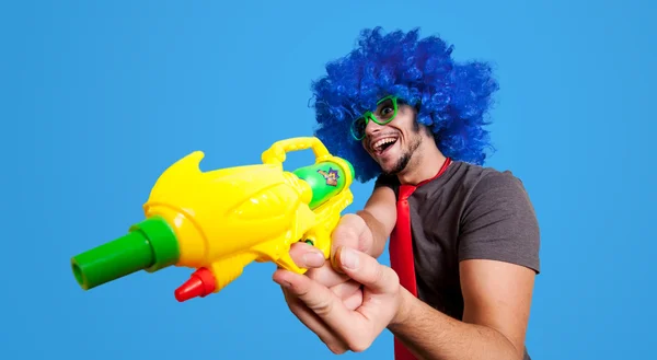 Rolig kille med blå peruk och vatten pistol — Stockfoto