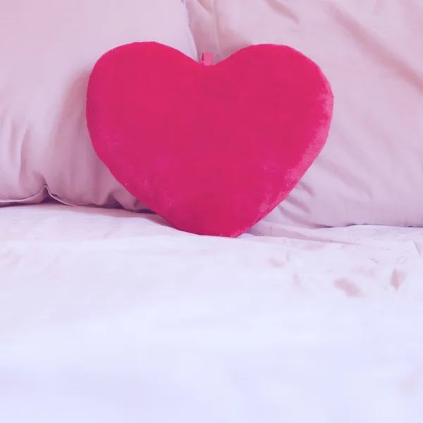 Almohada del corazón en la cama —  Fotos de Stock