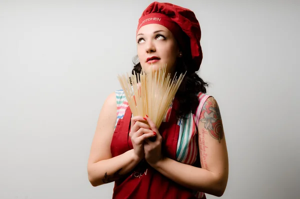 Beautiful tattooed pinup cook girl with spaghetti — Stock Photo, Image