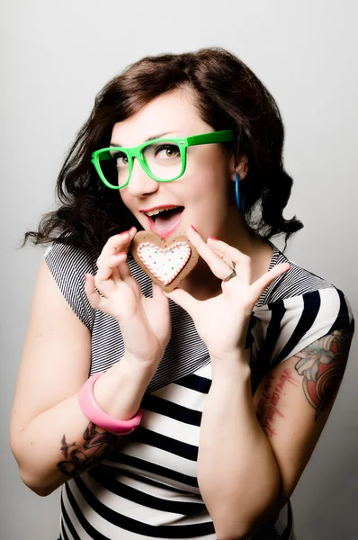 Tattoed pinup girl with heart biscuit — Stock Photo, Image