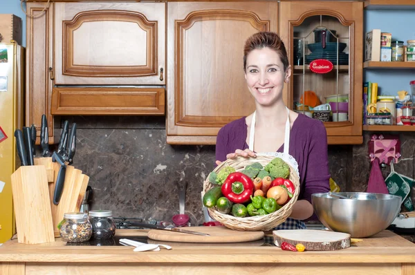 Beautiful housewife with basket of vegetables — Stock Photo, Image