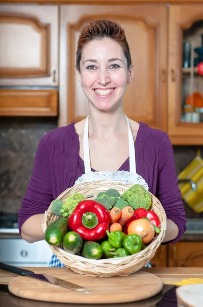 Beautiful housewife with basket of vegetables — Stock Photo, Image