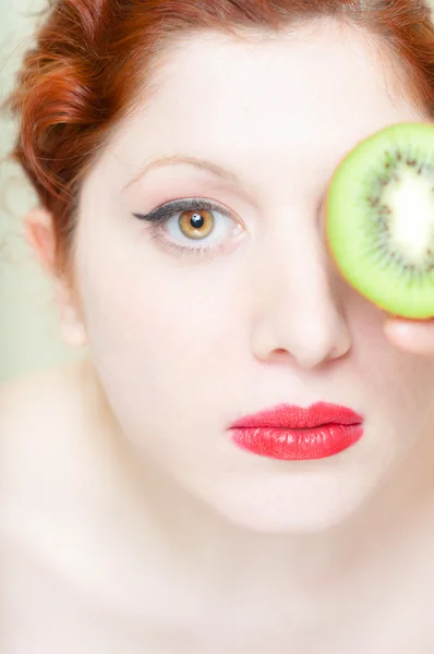 Bonito cabelo vermelho e lábios menina com kiwi — Fotografia de Stock