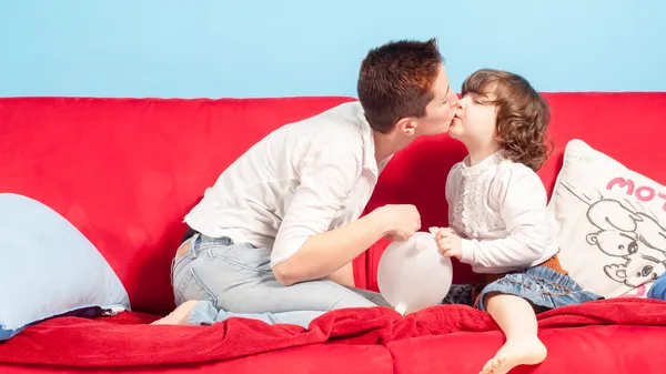 Moeder en kleine dochter knuffelen op de Bank — Stockfoto