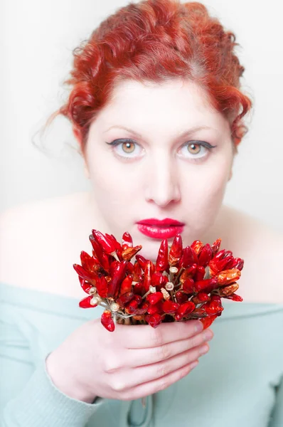 Vackra röda hår och läppar flicka med röda chilifrukter — Stockfoto