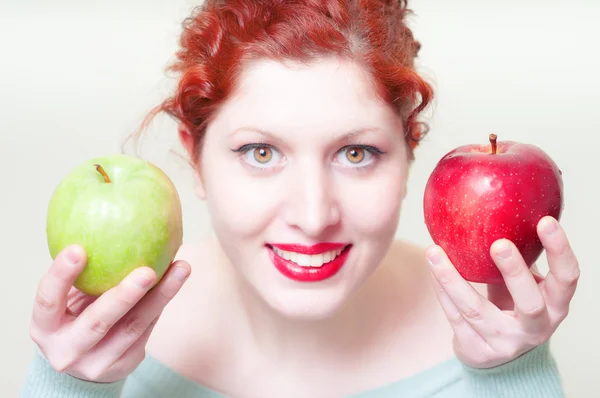 Vackra röda hår och läppar flicka med gröna och röda äpple — Stockfoto