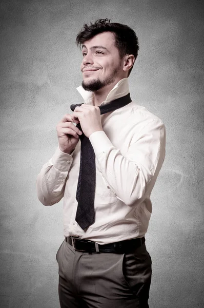 Сексуальный стильный бизнесмен регулирует галстук — стоковое фото