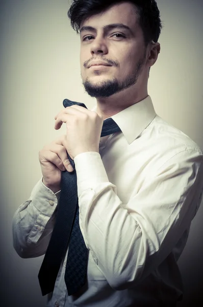 Sexy stylish businessman adjusting tie — Stock Photo, Image