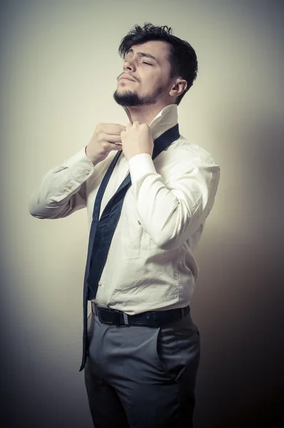 Sexy stylish businessman adjusting tie — Stock Photo, Image
