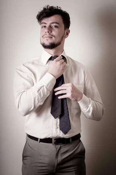 Sexy stylish businessman adjusting tie — Stock Photo, Image