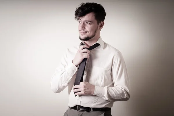 Сексуальный стильный бизнесмен регулирует галстук — стоковое фото
