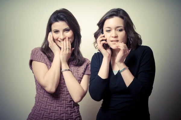 Két gyönyörű lányok pletykálkodás a telefon — Stock Fotó