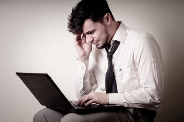 stresli iş adamı kullanarak dizüstü bilgisayar