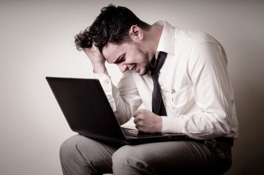stresli iş adamı kullanarak dizüstü bilgisayar