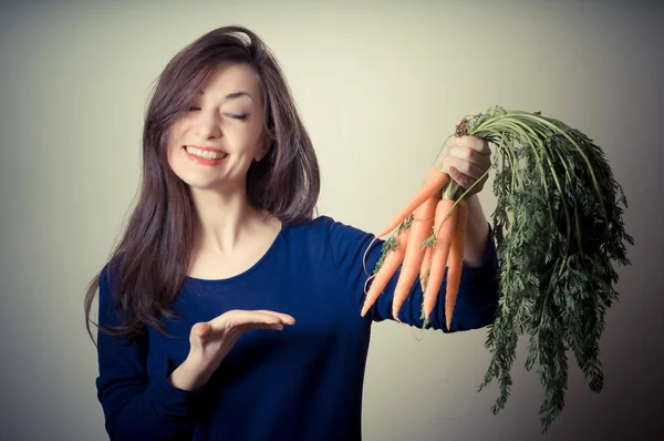 Beautiful woman with carrots — Stock Photo, Image