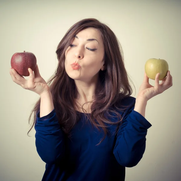 Beautiful woman choosing red or yellow apples — Stock Photo, Image