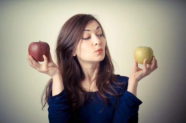 Beautiful woman choosing red or yellow apples — Stock Photo, Image