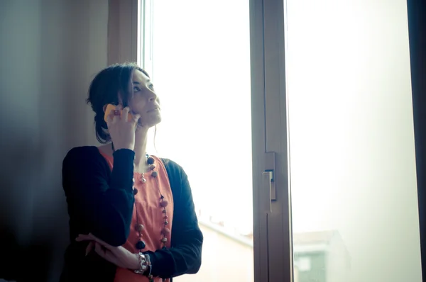 Beautiful woman at home at the phone — Stock Photo, Image