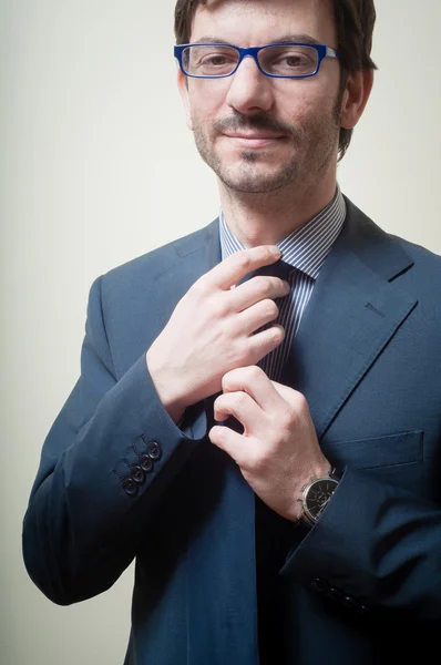 Успешный бизнесмен регулируя галстук — стоковое фото