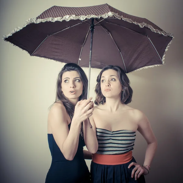 Vintage portrait of two young women with umbrella — Stock Photo, Image