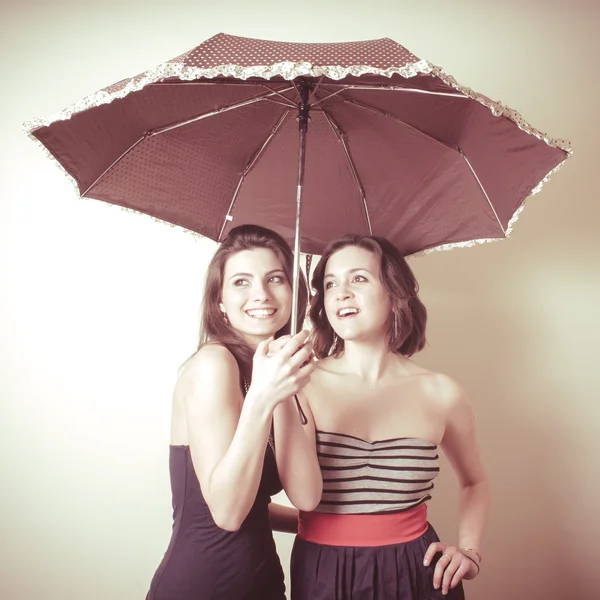 Vintage portrait of two young women with umbrella — Stock Photo, Image