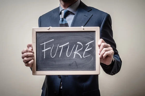 Empresário segurando quadro negro futuro escrito — Fotografia de Stock