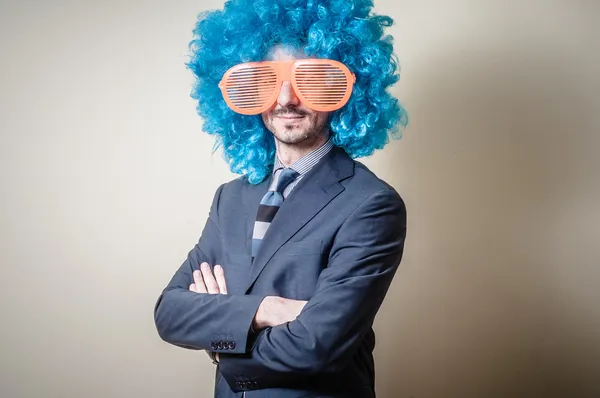 Hombre de negocios divertido con grandes gafas de color naranja y peluca azul — Foto de Stock