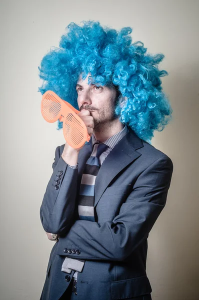 Hombre de negocios divertido con grandes gafas de color naranja y peluca azul — Foto de Stock