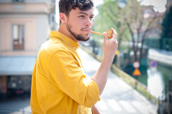 Молодий чоловік палить трубу — стокове фото