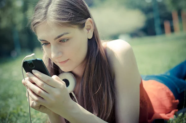 Prachtige model jonge vrouw op de telefoon in het park — Stockfoto