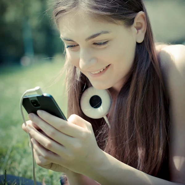 Hermosa modelo joven en el teléfono en el parque — Foto de Stock