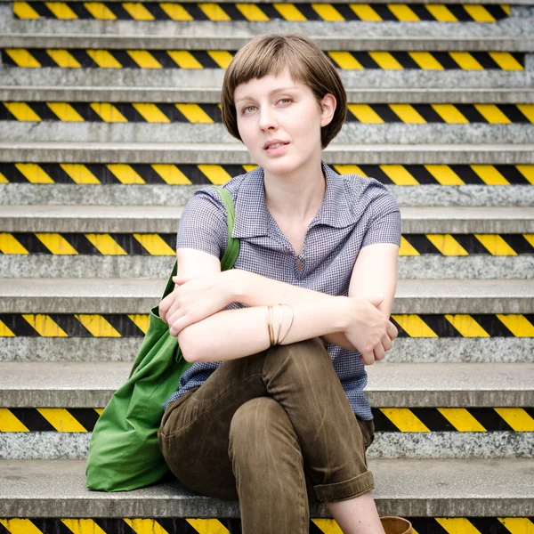 Young beautiful hipster woman sitting on the stairs — Stock Photo, Image
