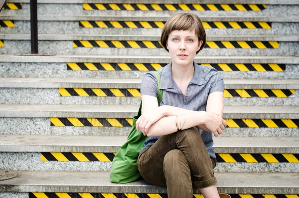 Young beautiful hipster woman sitting on the stairs — Stock Photo, Image