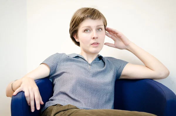 Young beautiful hipster woman sitting in the armchair — Stock Photo, Image