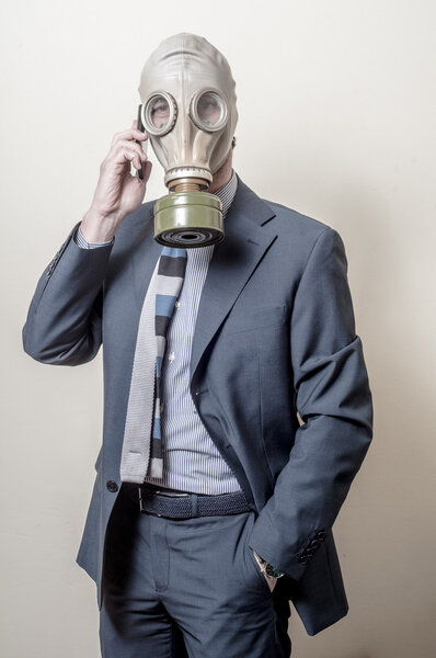 businessman with gas mask with phone
