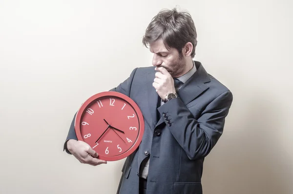 Businessman with clock doubtful — Stock Photo, Image