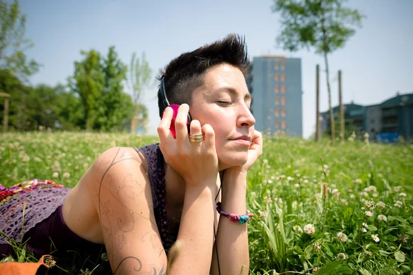 Bela hipster cabelo curto mulher ouvir música no parque — Fotografia de Stock