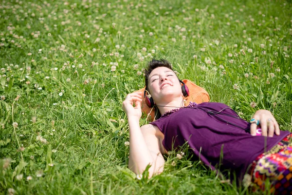 Bella hipster capelli corti donna ascoltare musica nel parco — Foto Stock