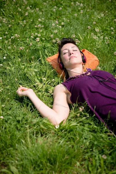 Belle femme hipster cheveux courts écouter de la musique dans le parc — Photo