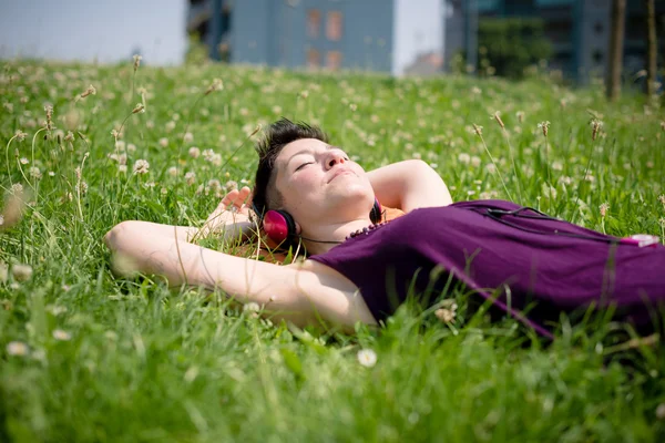 Belle femme hipster cheveux courts écouter de la musique dans le parc — Photo