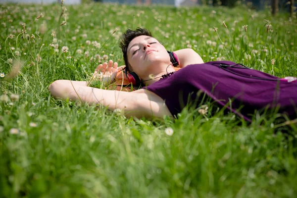 Belle femme hipster cheveux courts écouter de la musique dans le parc — Photo