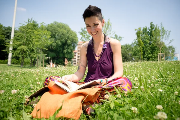 Bellissimo hipster capelli corti donna lettura libro nel parco — Foto Stock