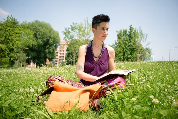 Bellissimo hipster capelli corti donna lettura libro nel parco — Foto Stock