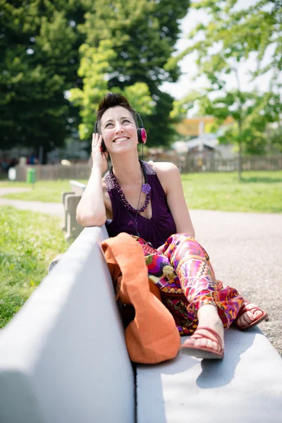 Bella hipster capelli corti donna ascoltare musica nel parco — Foto Stock
