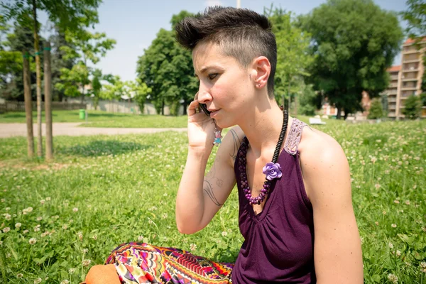 Mooie hipster kort haar vrouw in het park — Stockfoto