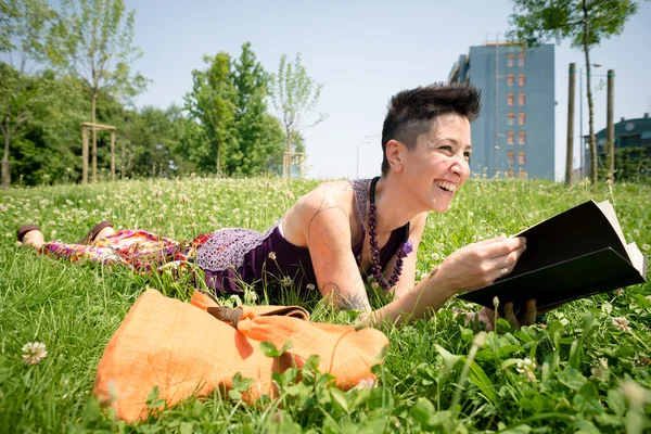 Bellissimo hipster capelli corti donna lettura libro nel parco — Foto Stock