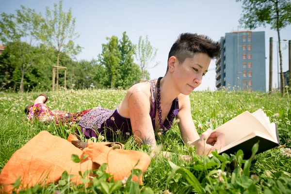 Bellissimo hipster capelli corti donna lettura libro nel parco — Foto Stock