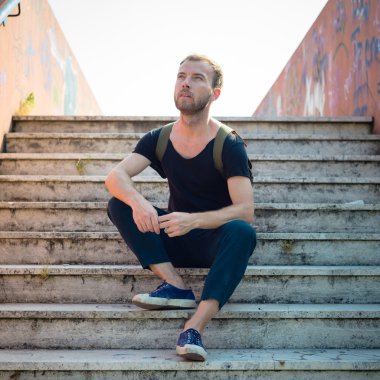 hipster modern şık sarışın adam merdivenlerde oturan