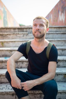 hipster modern şık sarışın adam merdivenlerde oturan